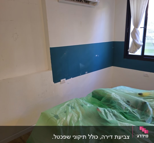 קיר צבוע בחדר עם מזגן ויריעות פלסטיק על הרצפה